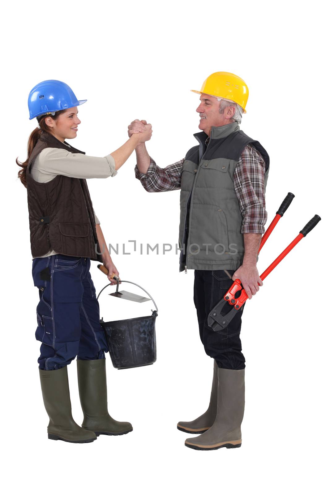 Male and female manual workers shaking hands