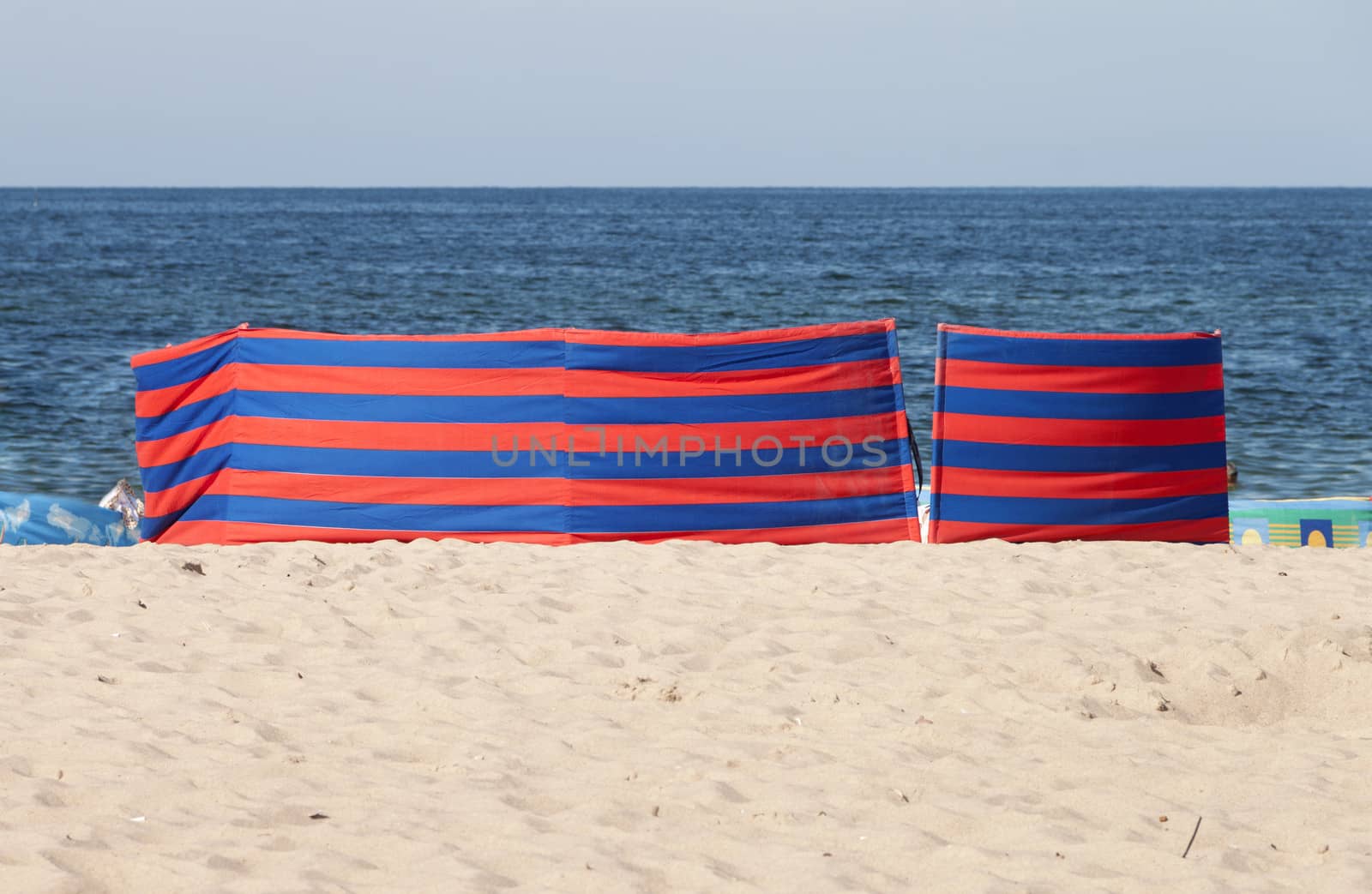 Red and blue striped windbreak at the beach