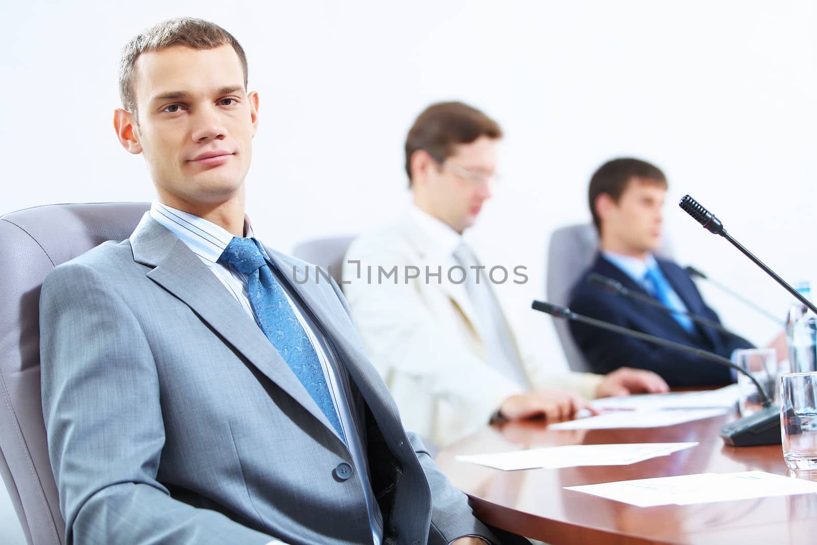 Image of three businesspeople at table at conference