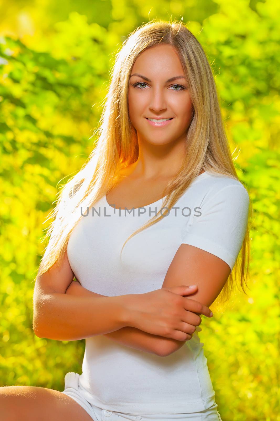 a beautiful blonde on a background of fuzzy foliage