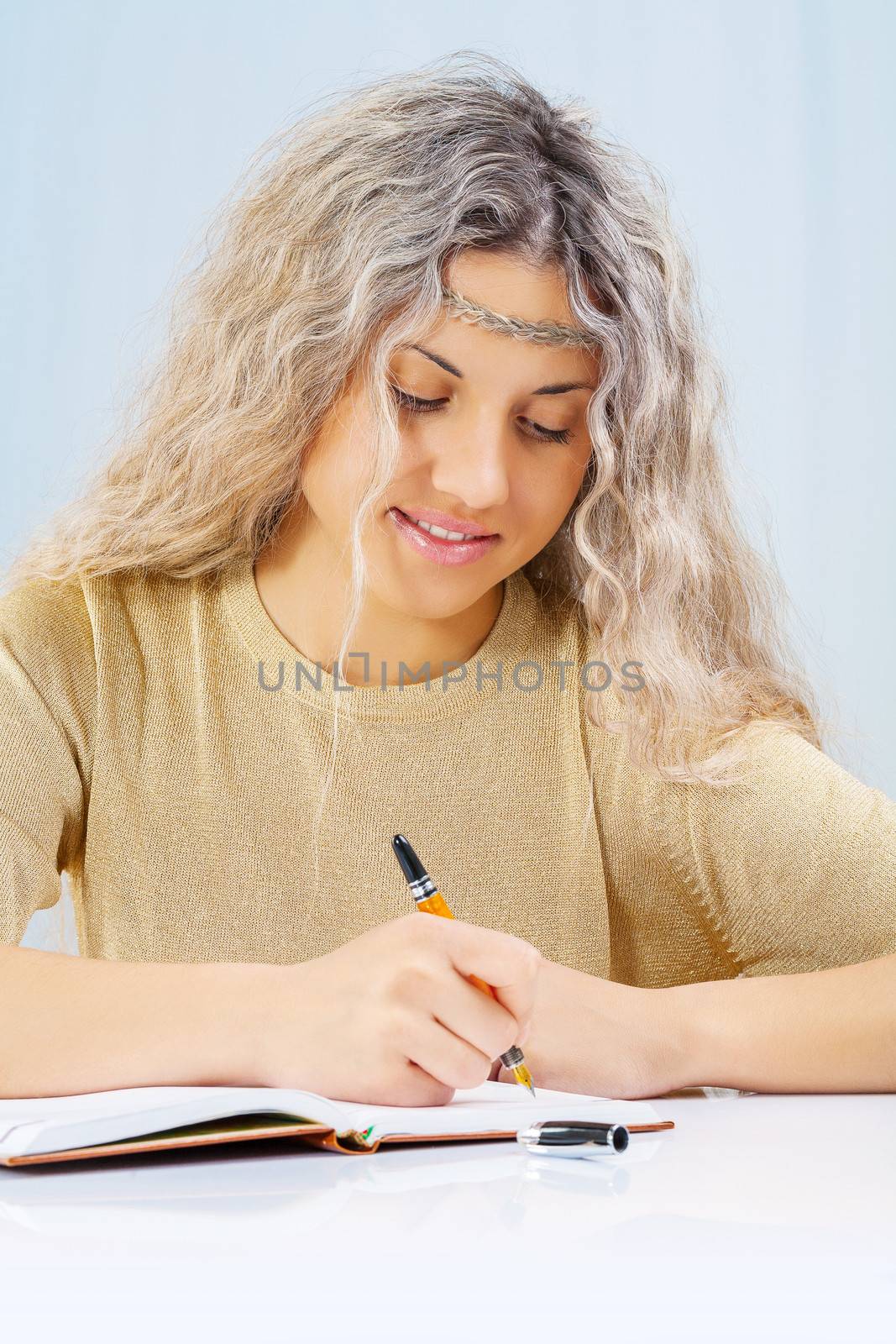 a blonde writing in notepad