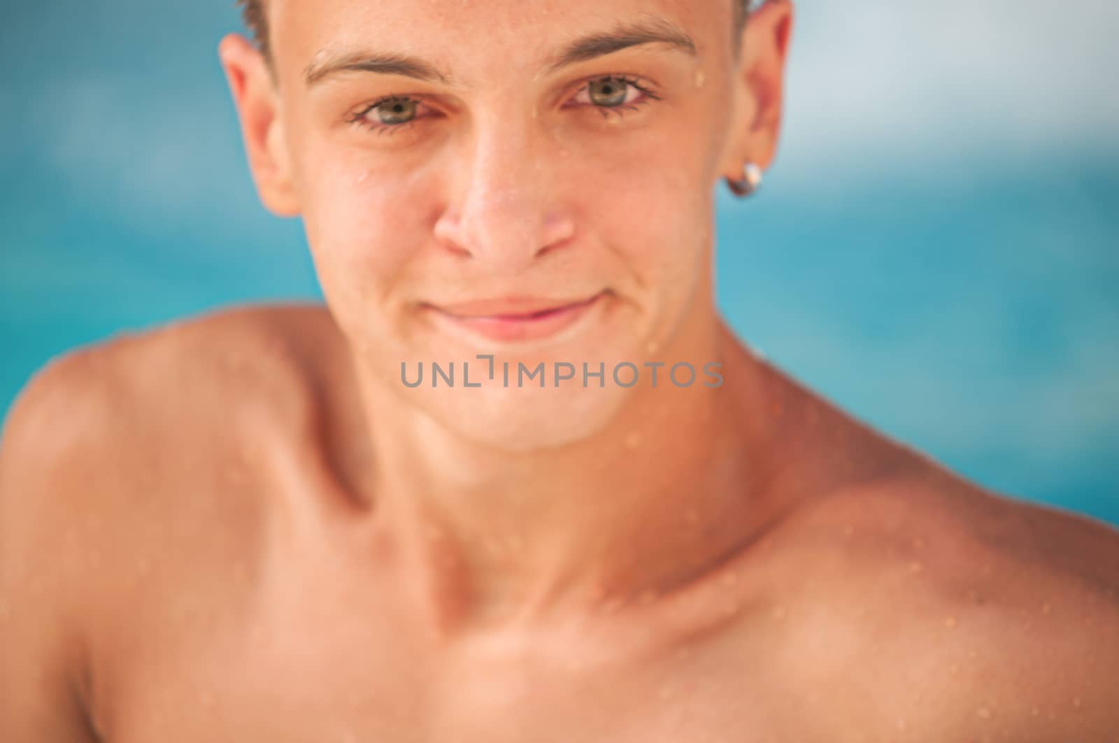 happy teen boy in blue swimming pool portrait  by LarisaP