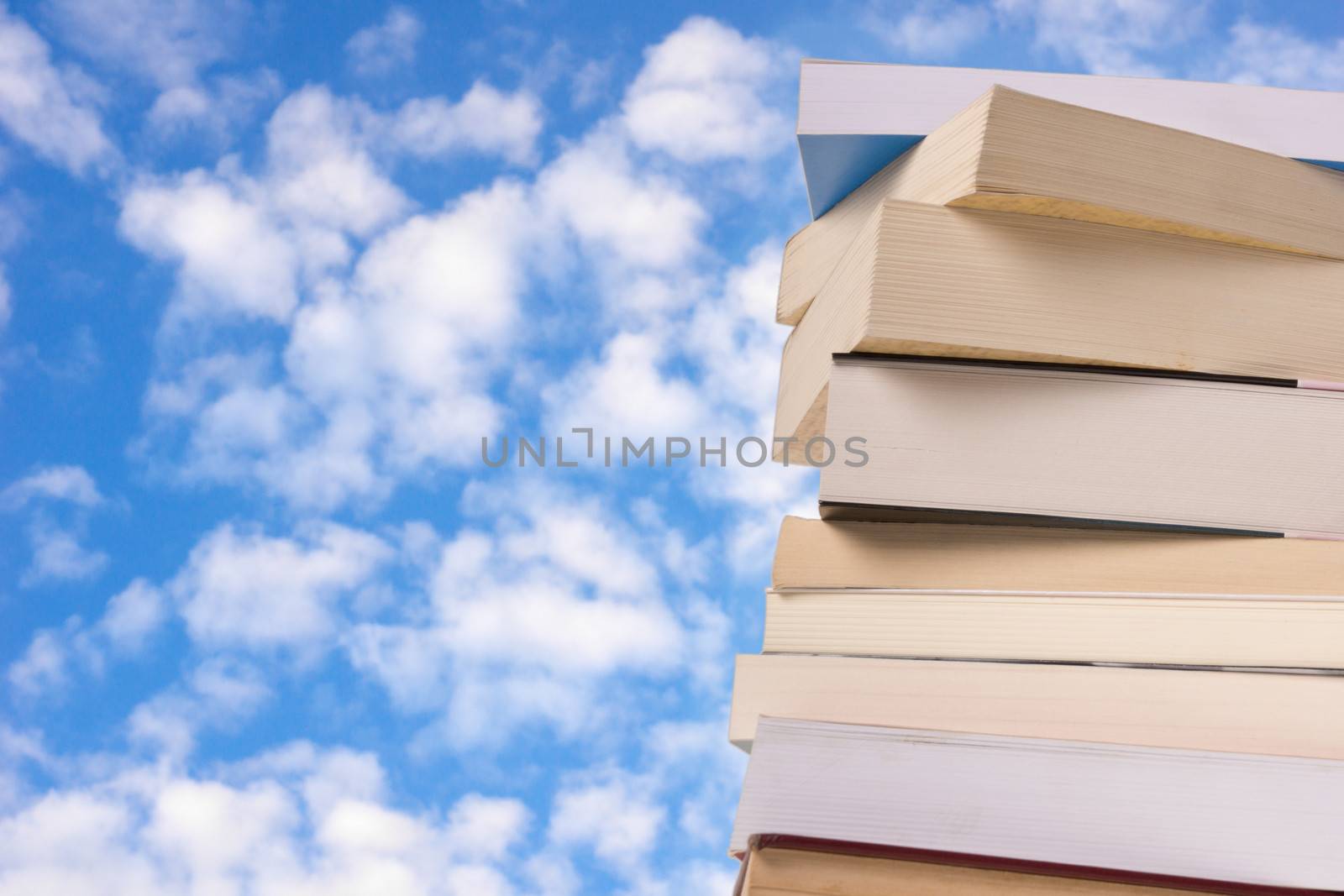 A stack of books with a sky background.