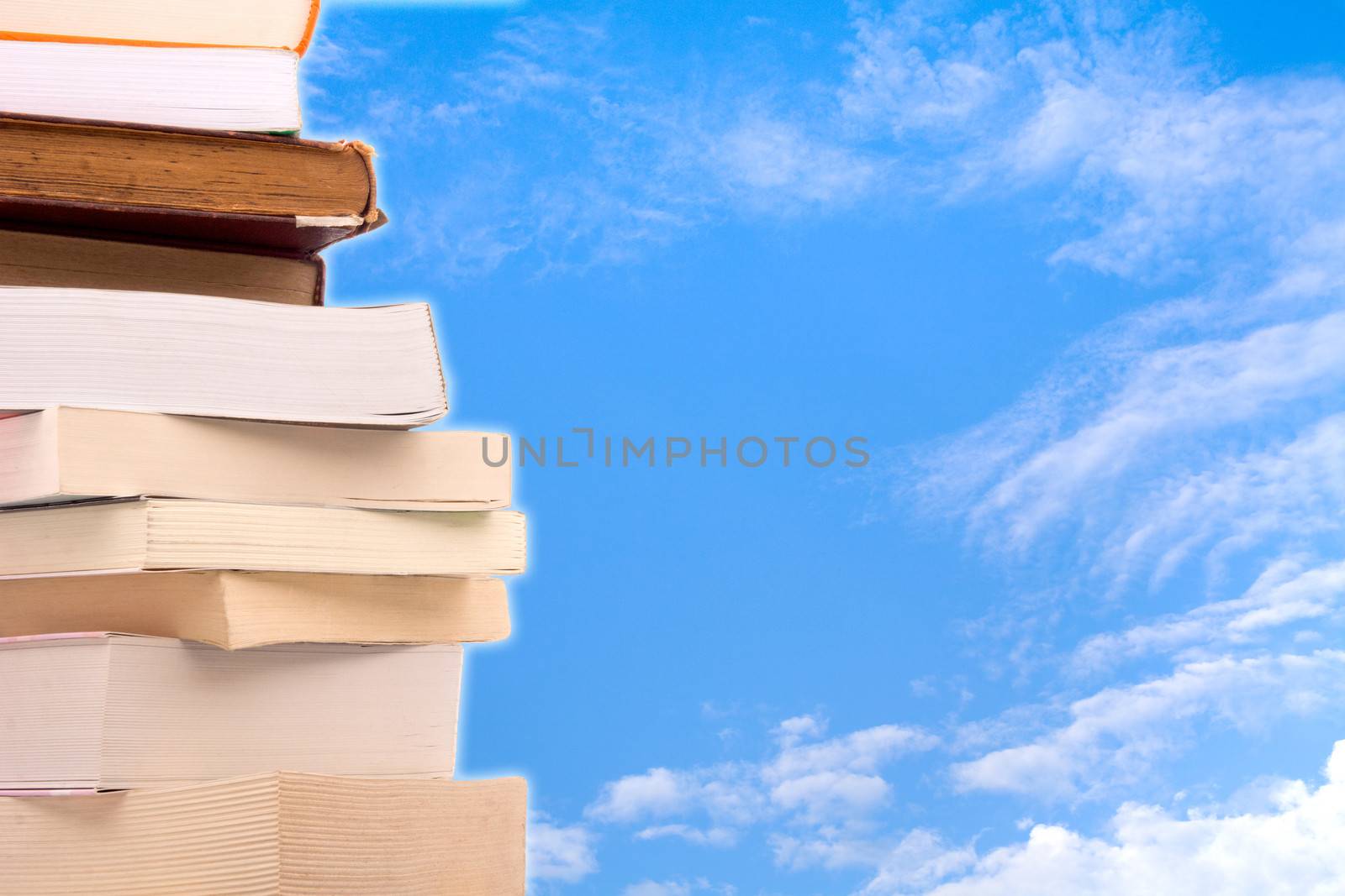 Old books in a stack with sky background