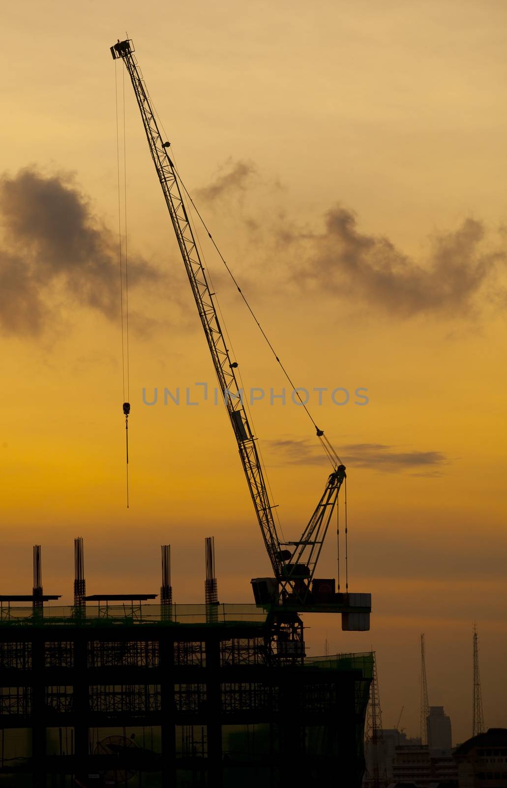 crane of building construction on dusky sky by khunaspix