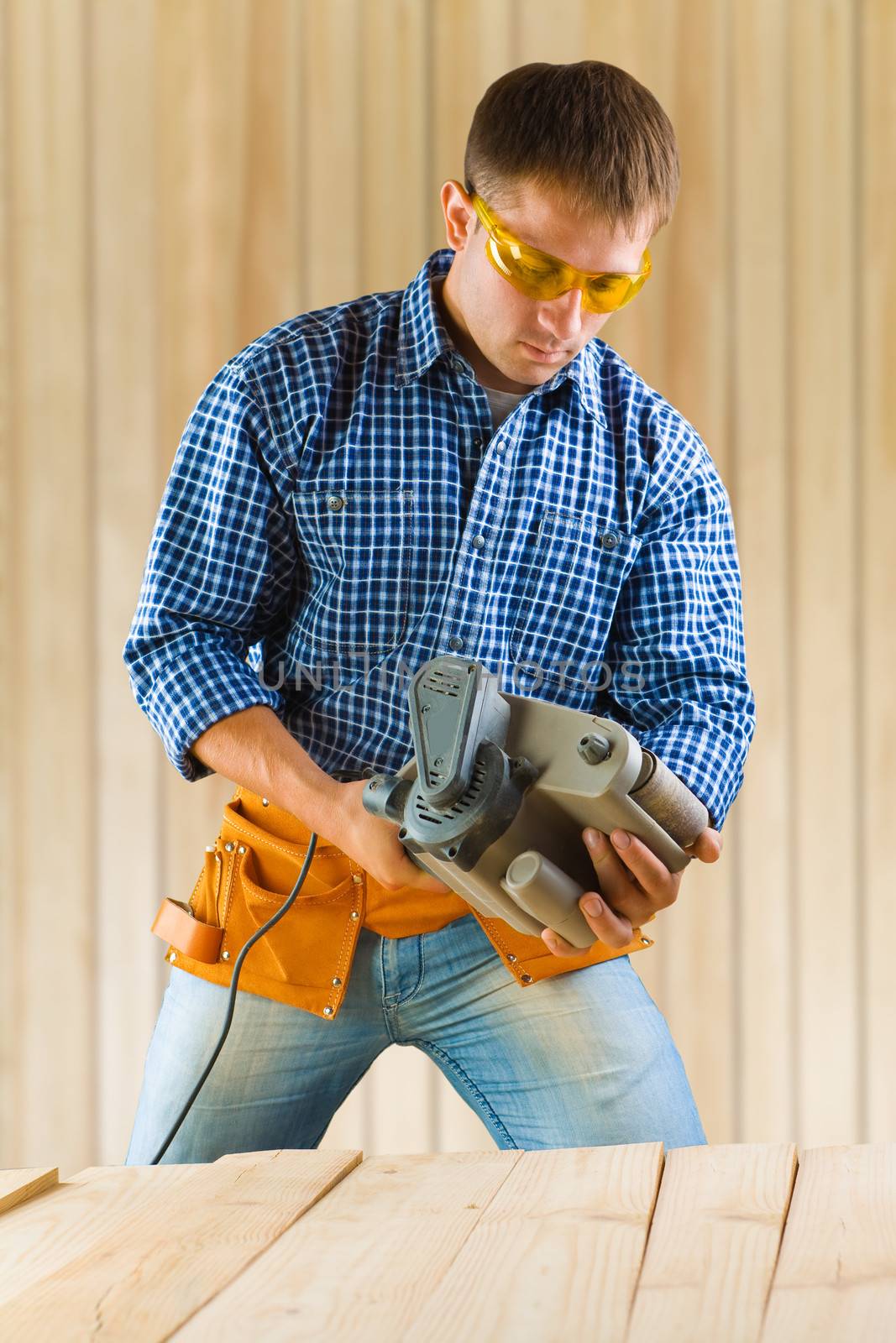 worker adjusting detail sander by mihalec