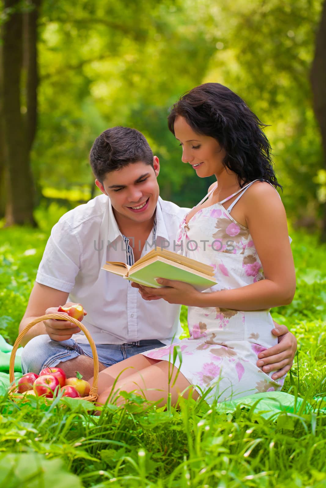 young couple sitting on grass in park