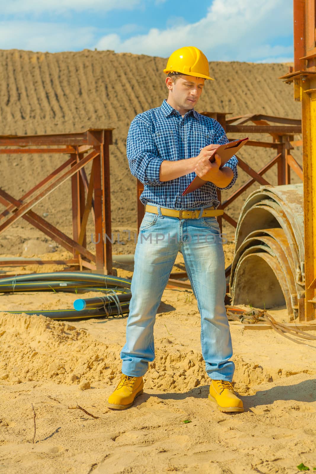 a young contractor writing in clipboard by mihalec