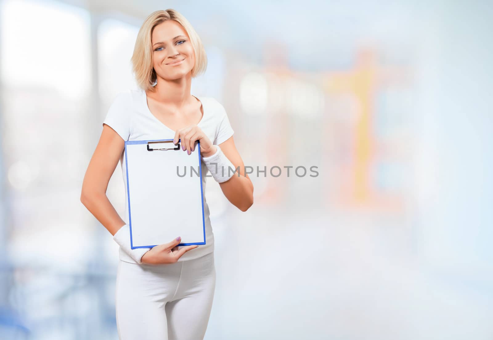 a young female in sports clothing holding clipboard