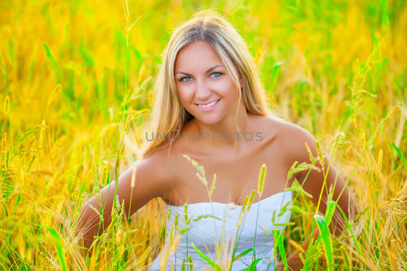 beautiful smiling blonde on wheat field