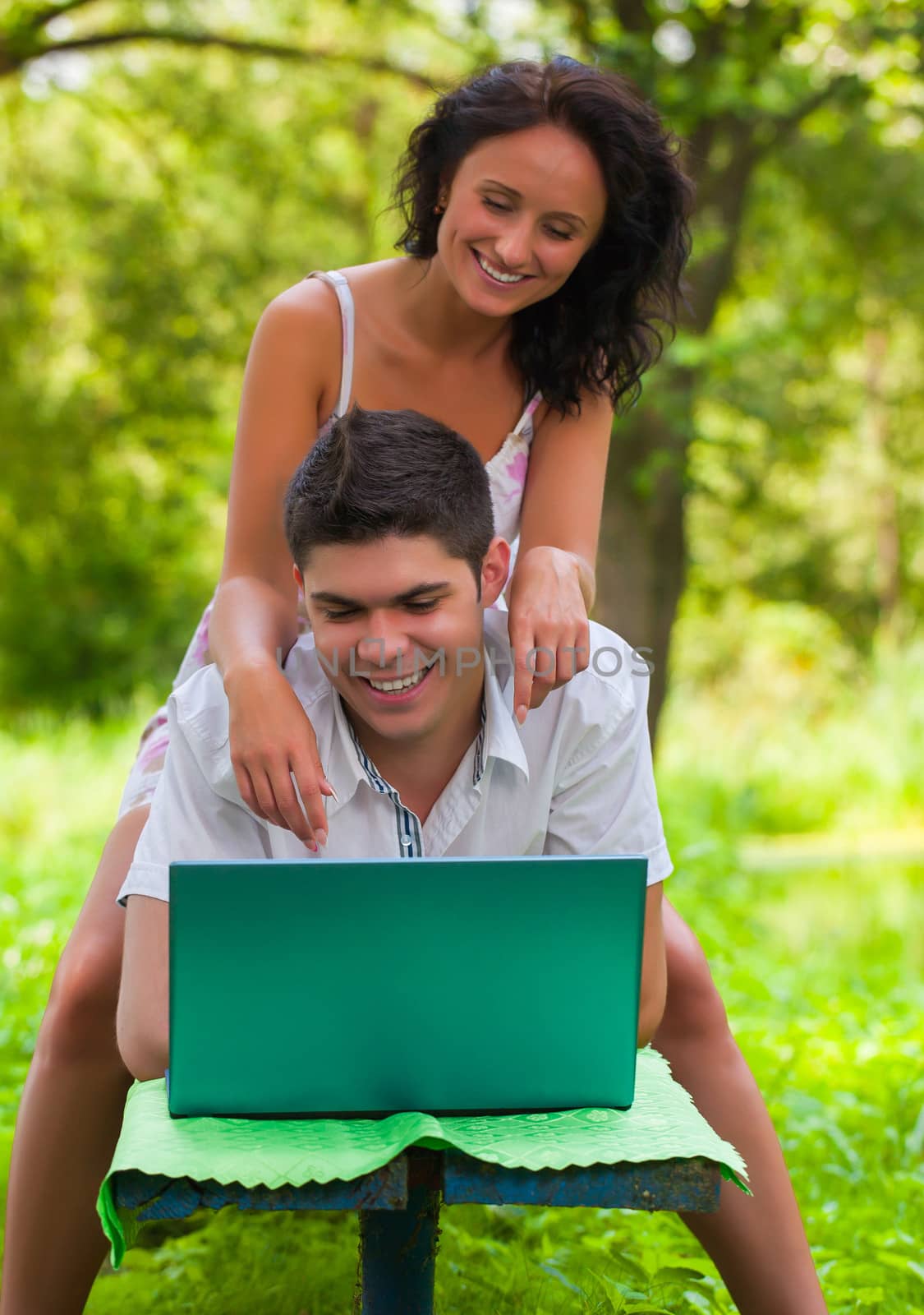 copule with laptop in park