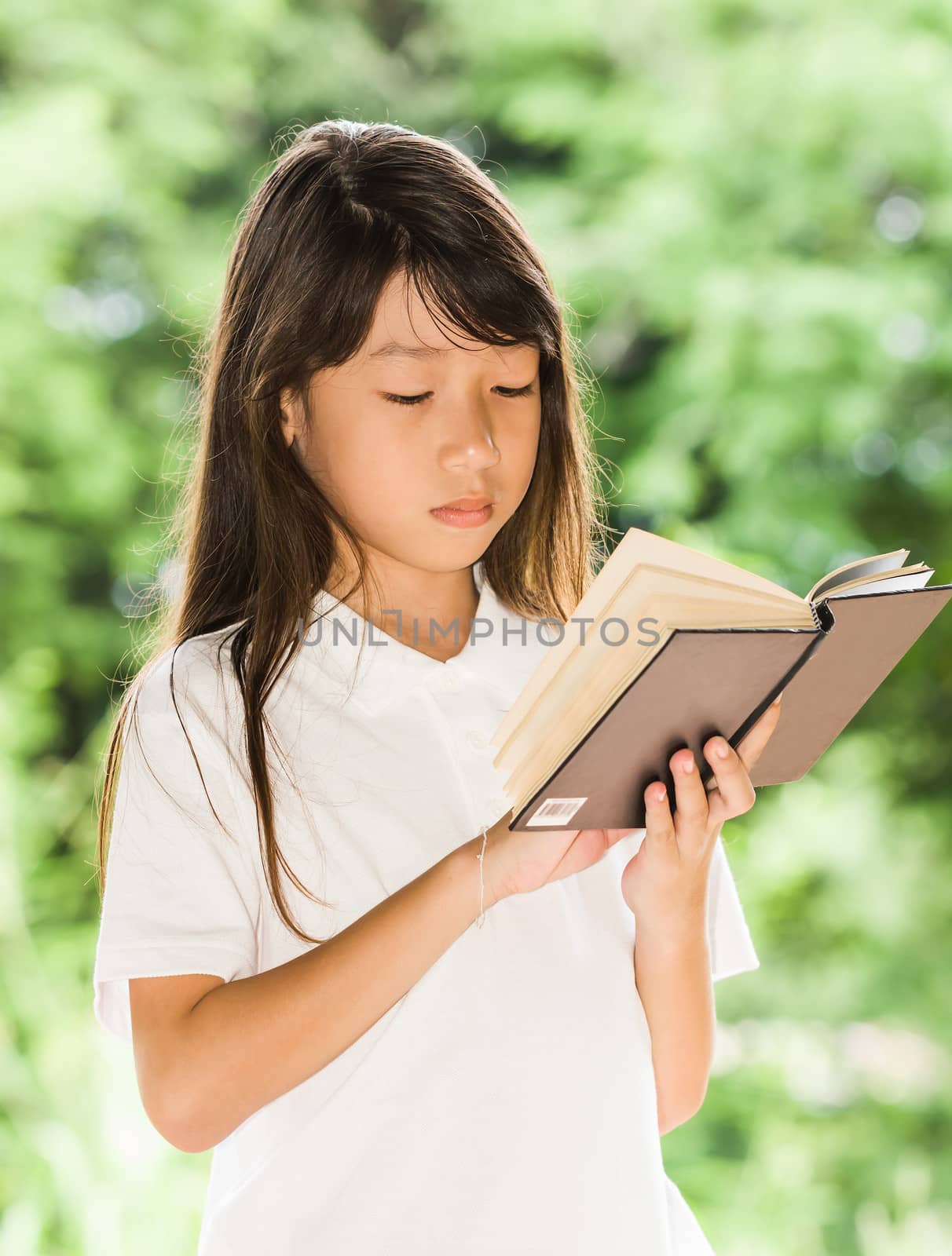Beautiful asian girl holding an open book,Reading background summer green park