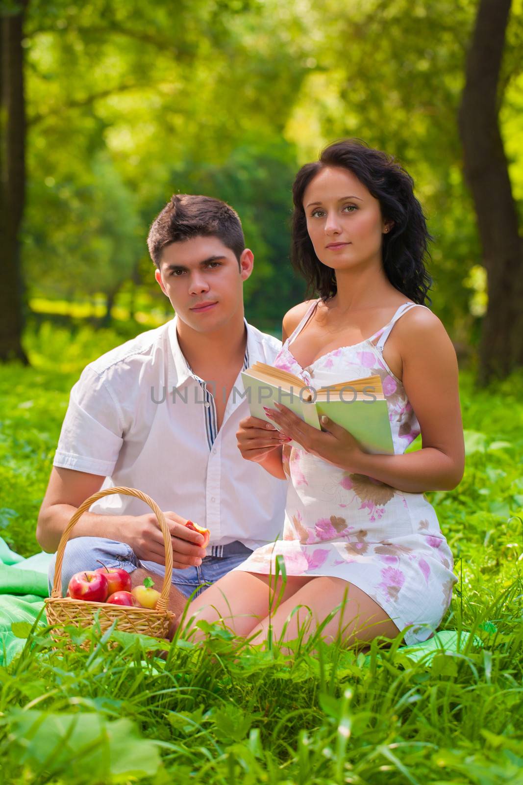 couple with book  looking at camera