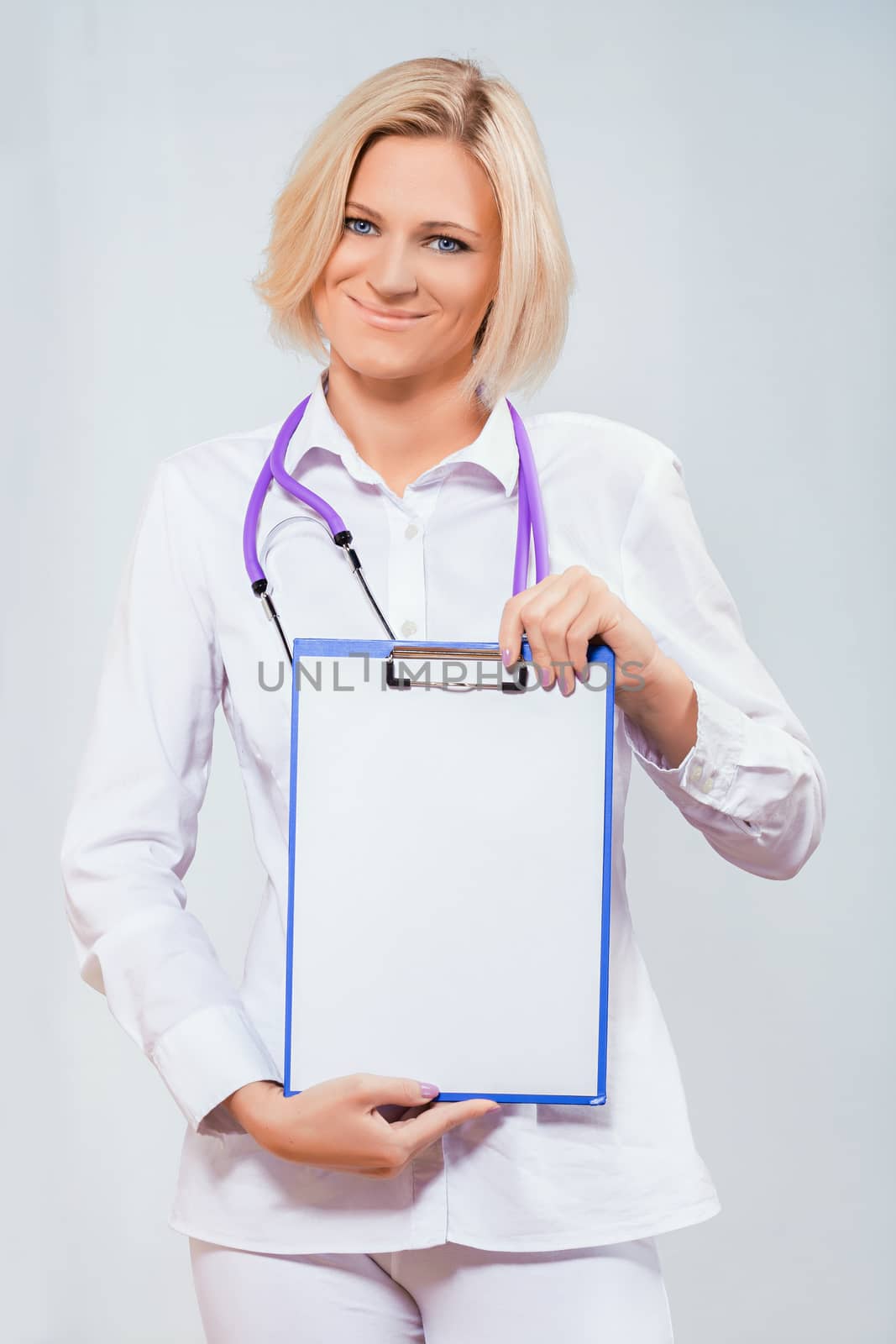 female doctor holding a clipboard by mihalec