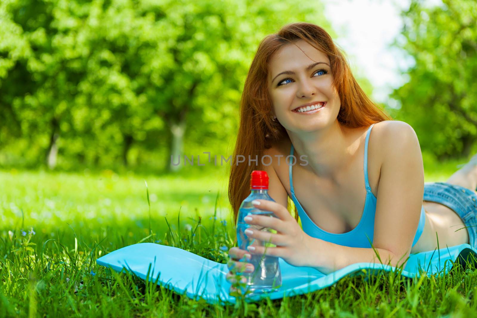 girl with bottle of water on grass