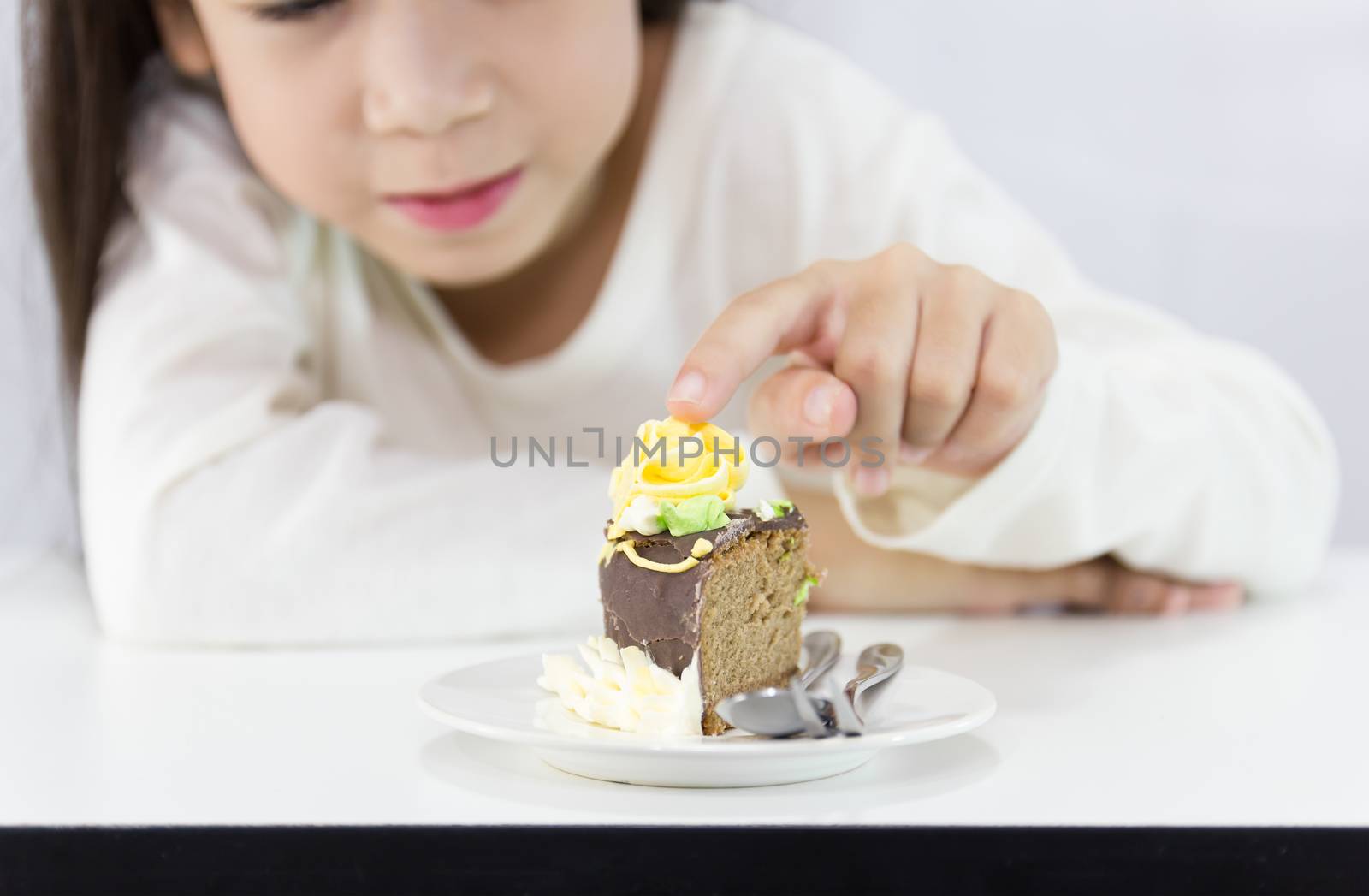 The girl stared cake for overcome by a temptation to eat a slice of a sweet cake