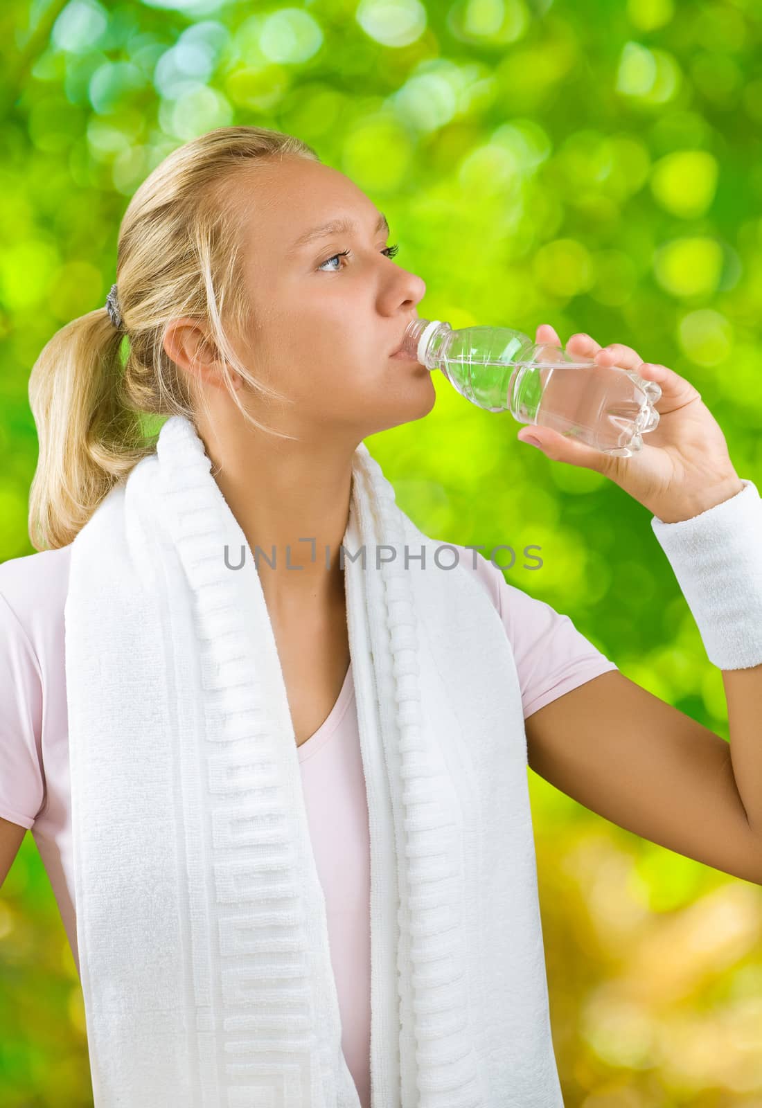 a girl drinking water fom small bottle by mihalec