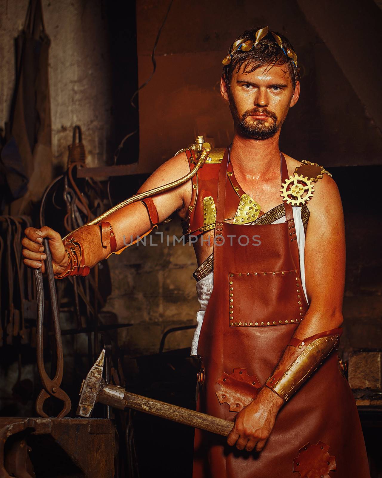 Hephaestus blacksmith in a leather apron in the blacksmith with hammer and clippers, anvil