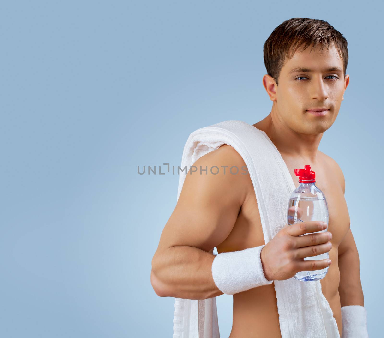 a muscular handsome man with bottle of water