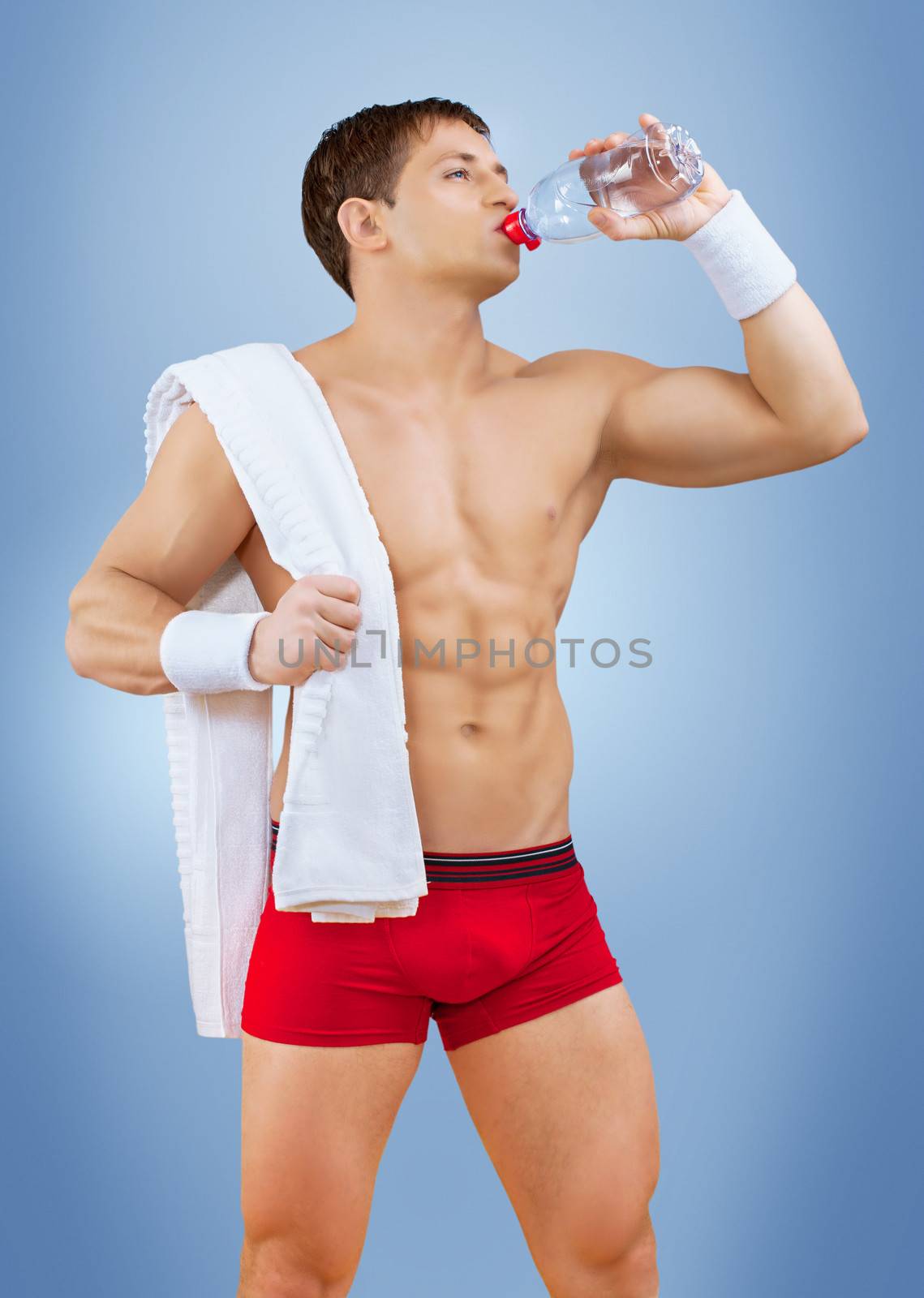 a muscular male drinking water from bottle