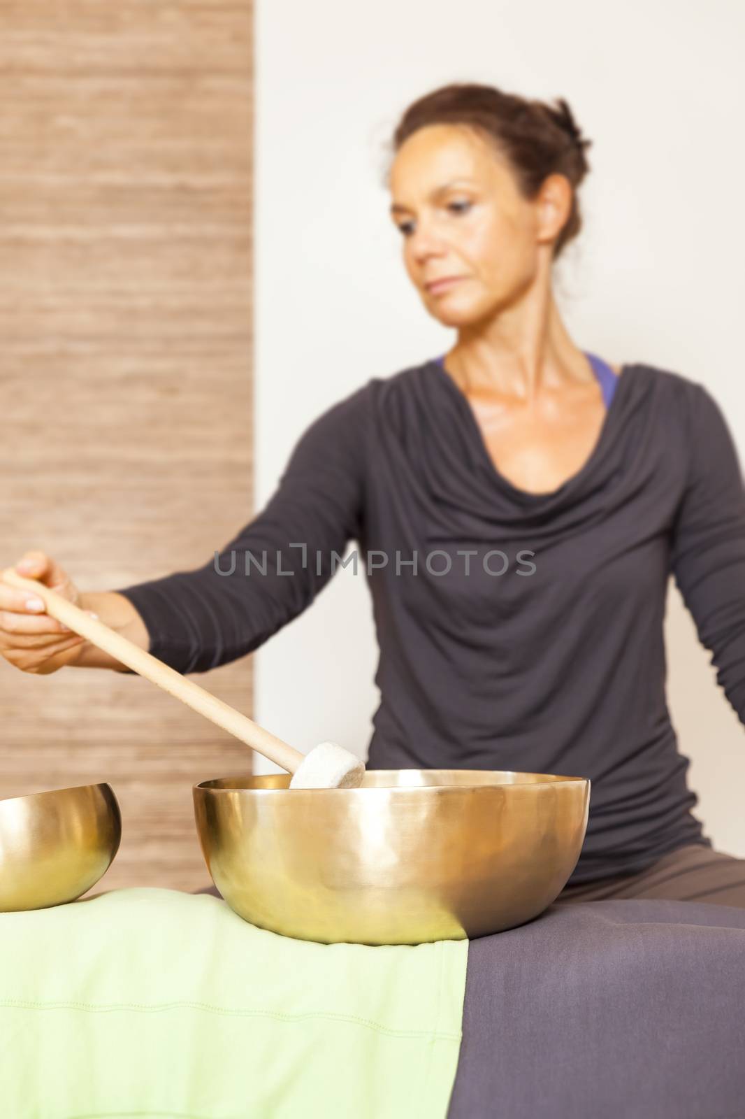 A woman is relaxing with singing bowls on her body