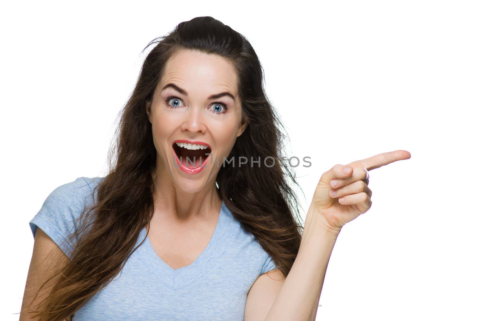 A very happy and surprised woman pointing to copy-space. Isolated on white.