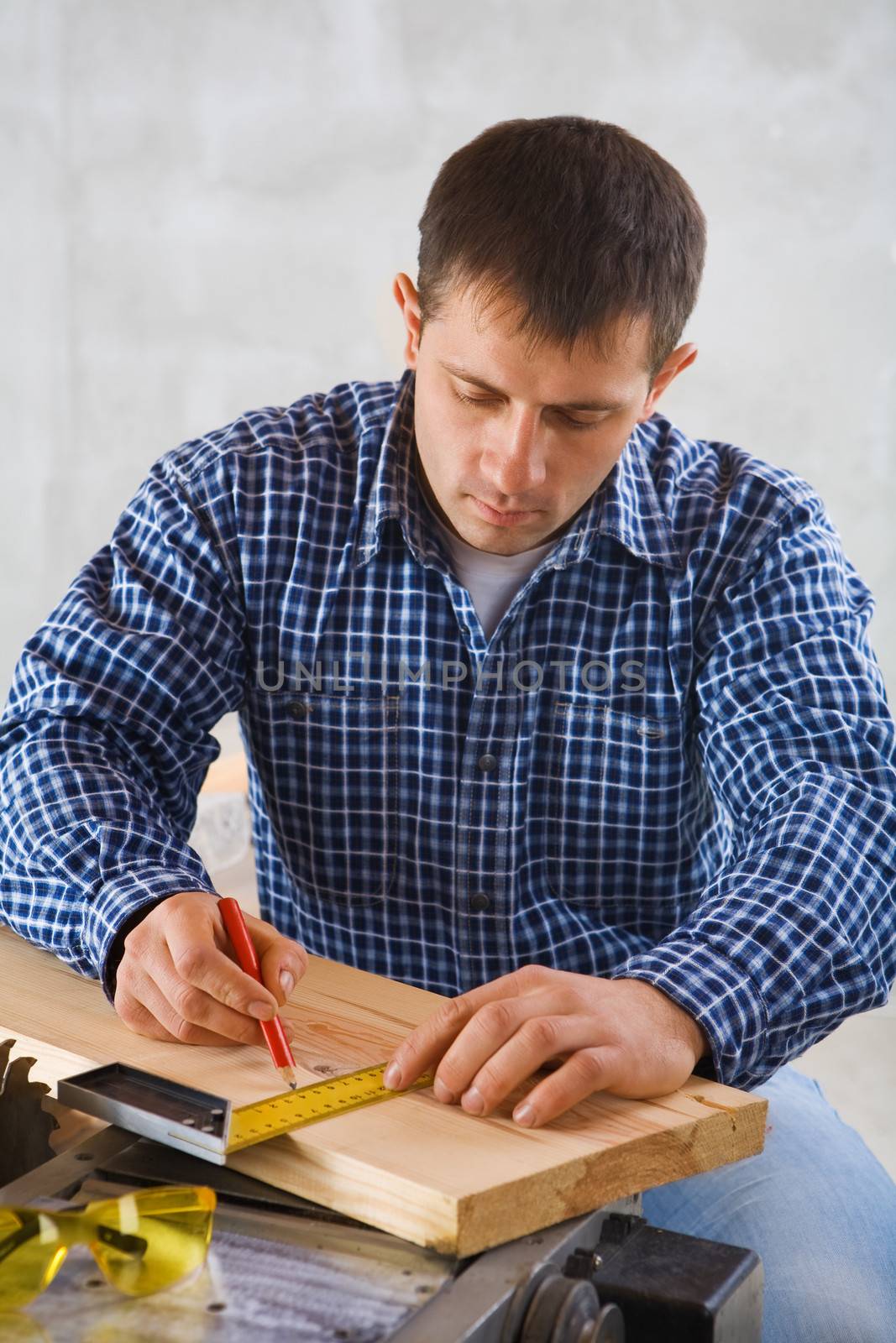 Contractor working with pencil and wooden board