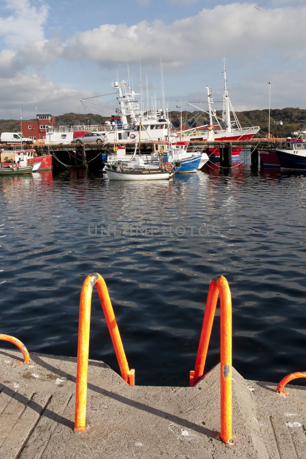 fishing boats moored in the calm waters of Killybegs harbour with ladder at foreground