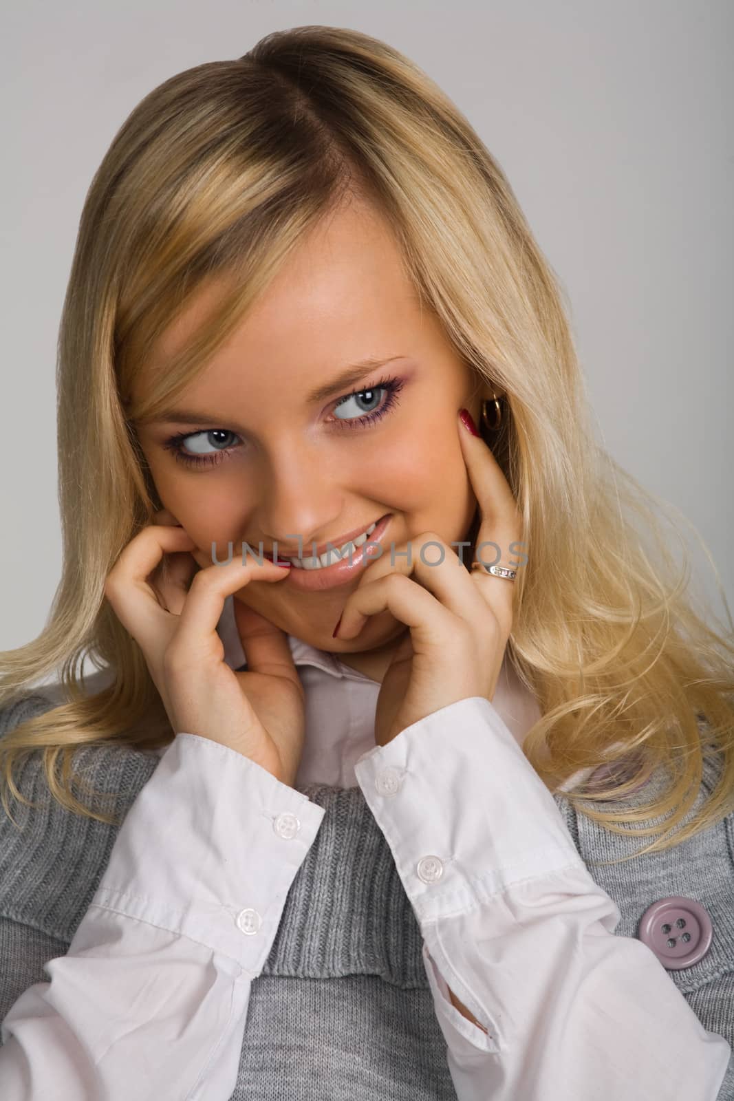 Portrait of the young beautiful smiling girl on a grey backgroun by mihalec