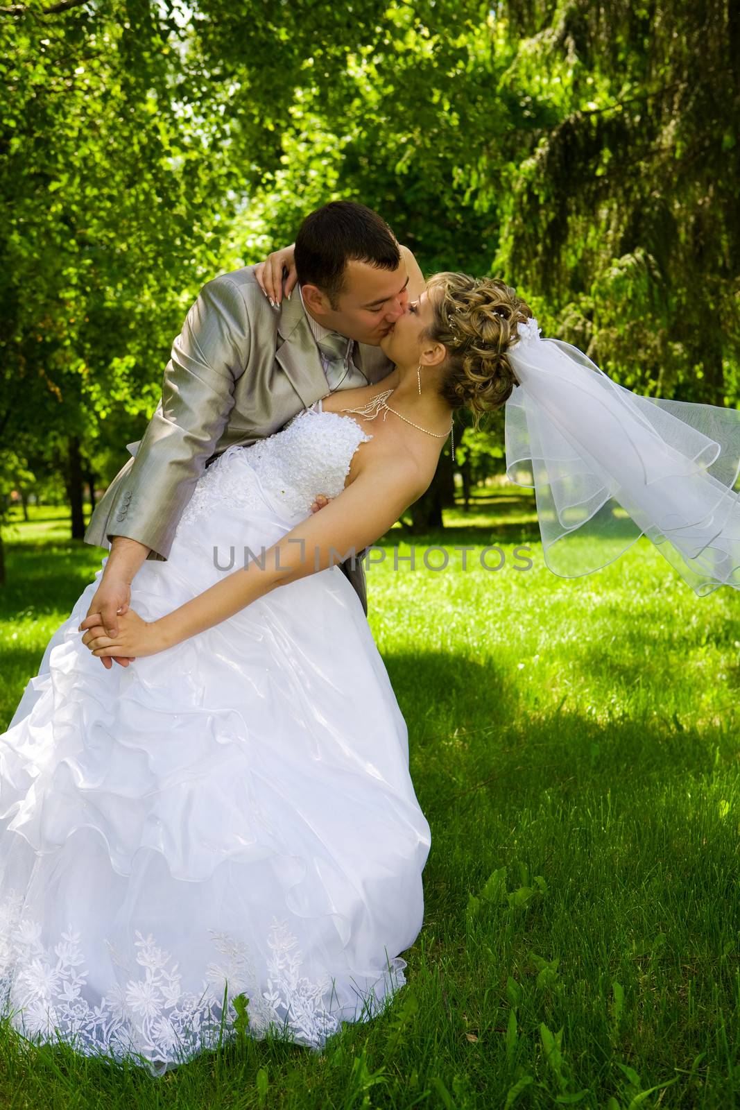 The groom holds the bride in park