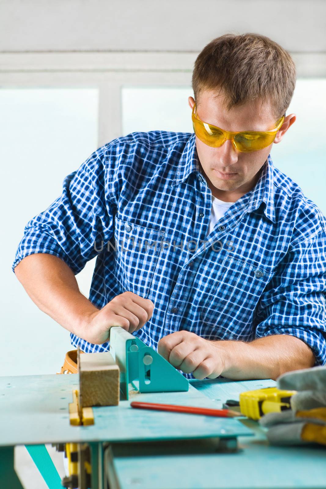 worker adjusts the woodworking mashine by mihalec