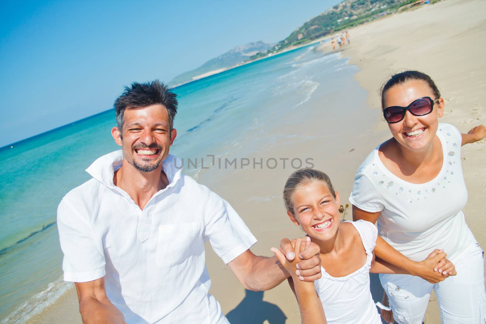 Photo of happy family running on the beach