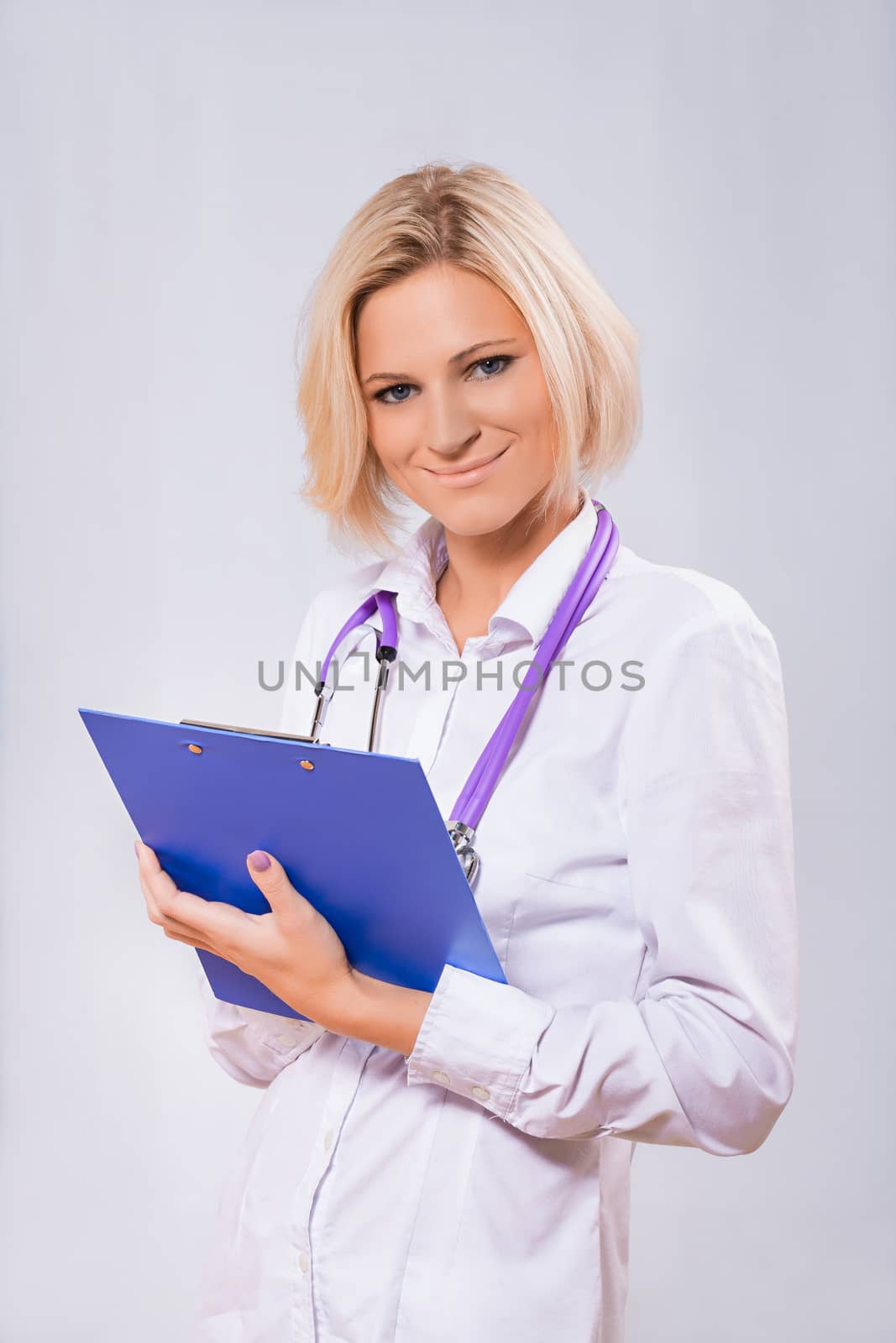 a female doctor holding clipboard by mihalec