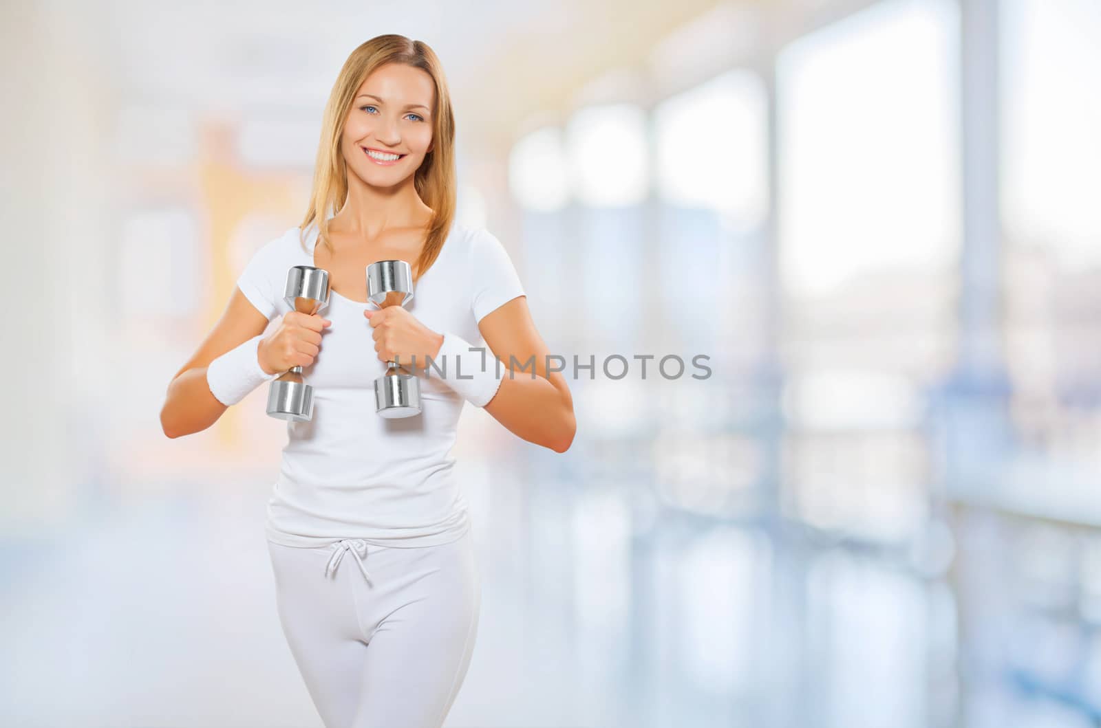 a female wearing sports clothes holding barbells