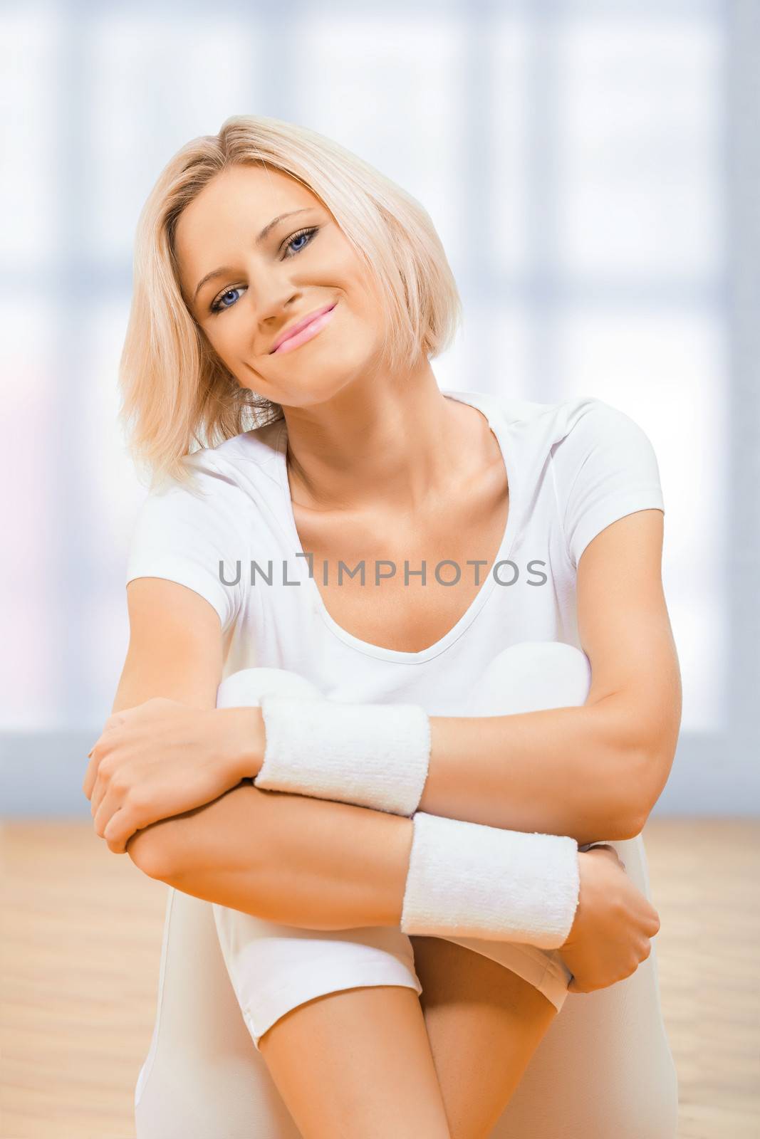 a sports girl sitting on wooden floor