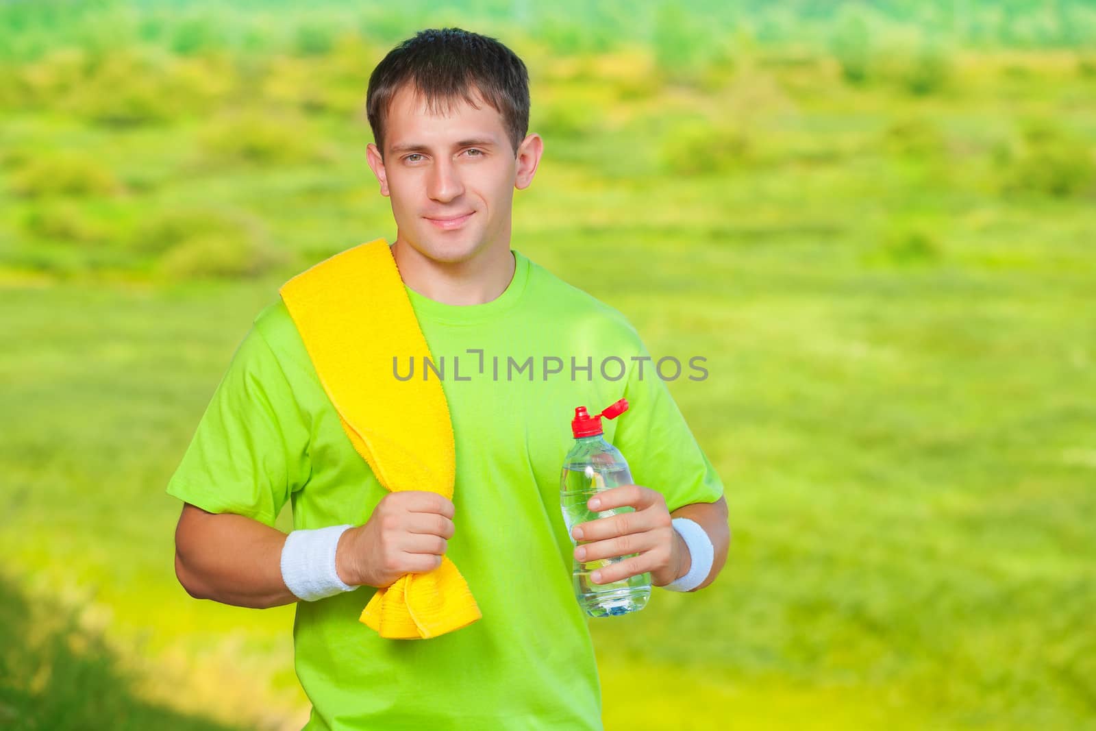 a sports man with towel holding bottle of water