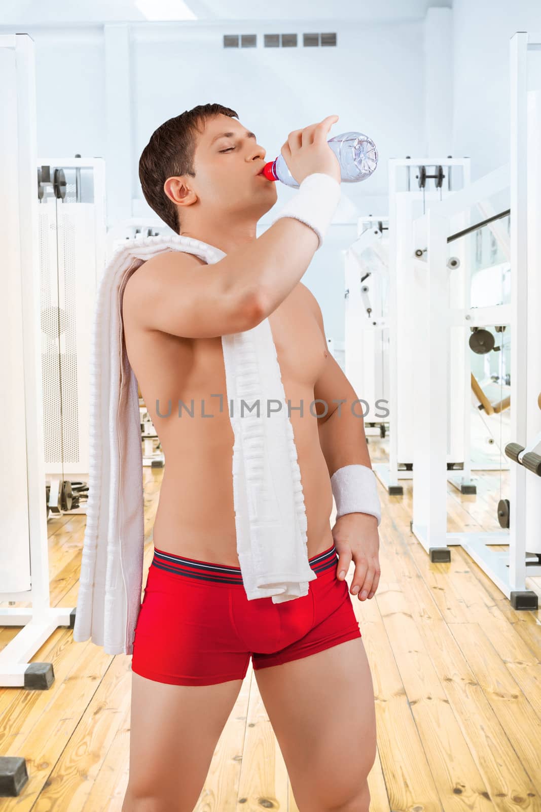 a sportsman drinking water in the gym
