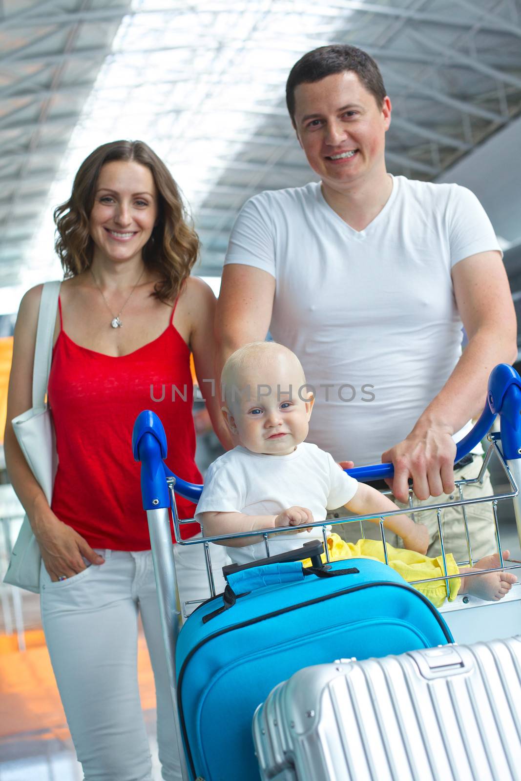 Standing traveling family with suitcases in airport