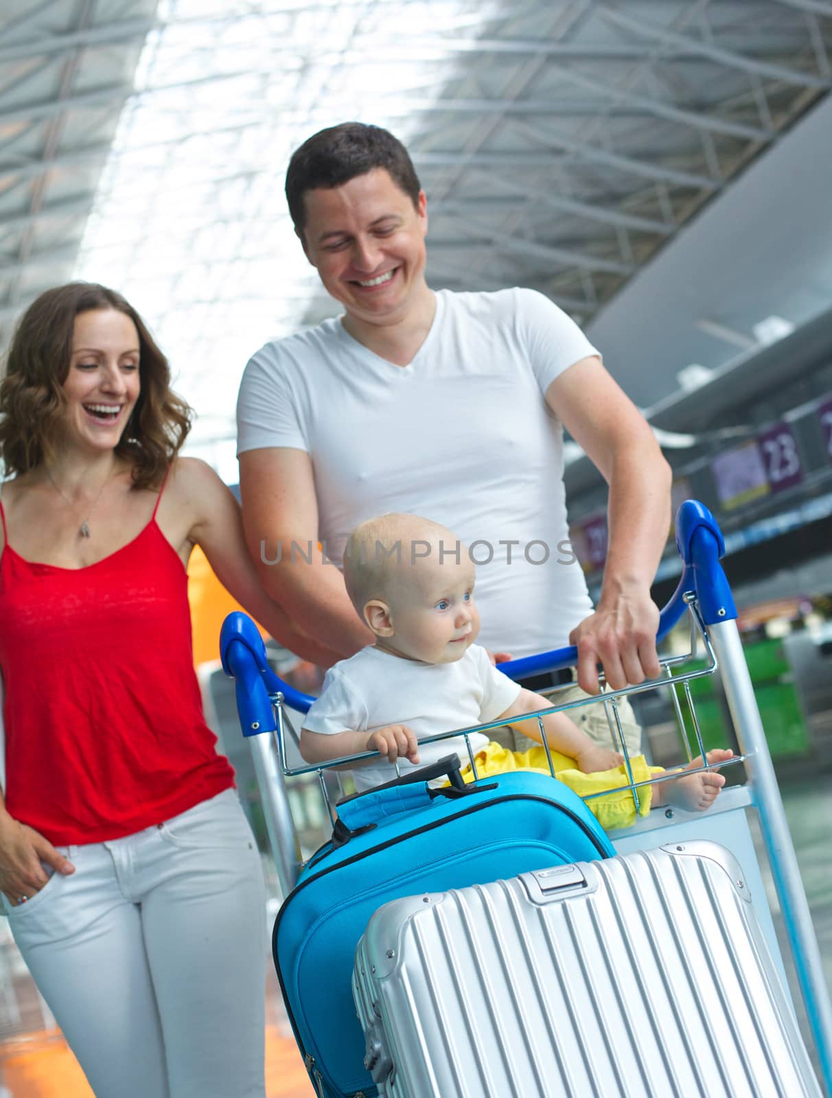 Standing traveling family with suitcases in airport