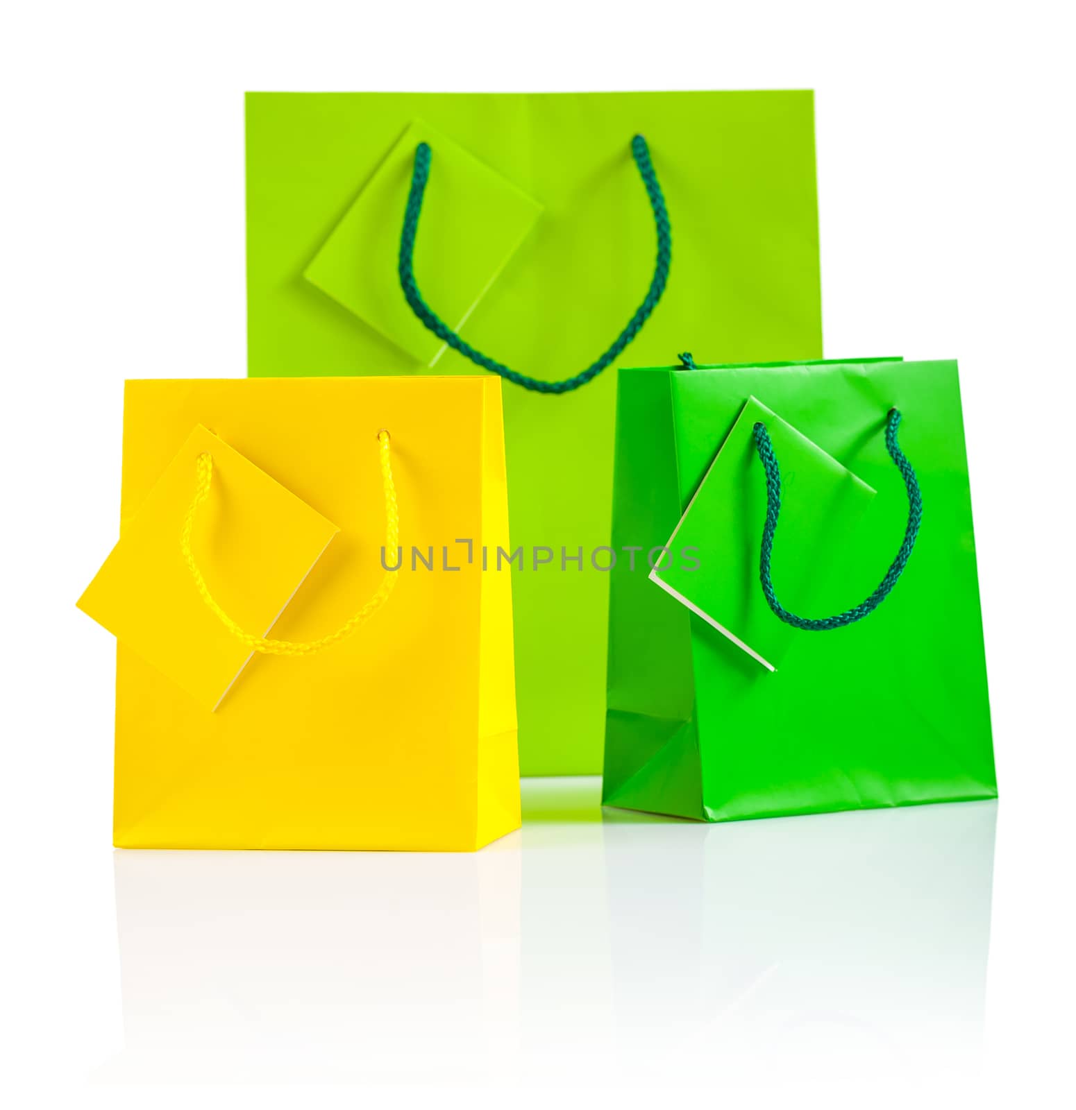 three colored paper bags isolated on white