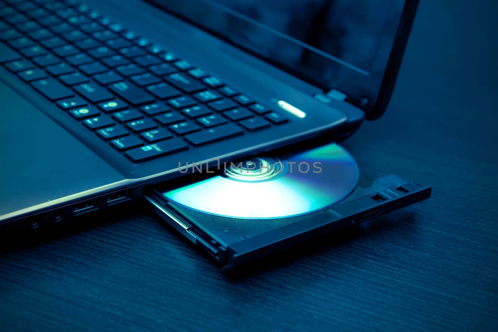 Laptop with open CD - DVD drive. Abstract light composition