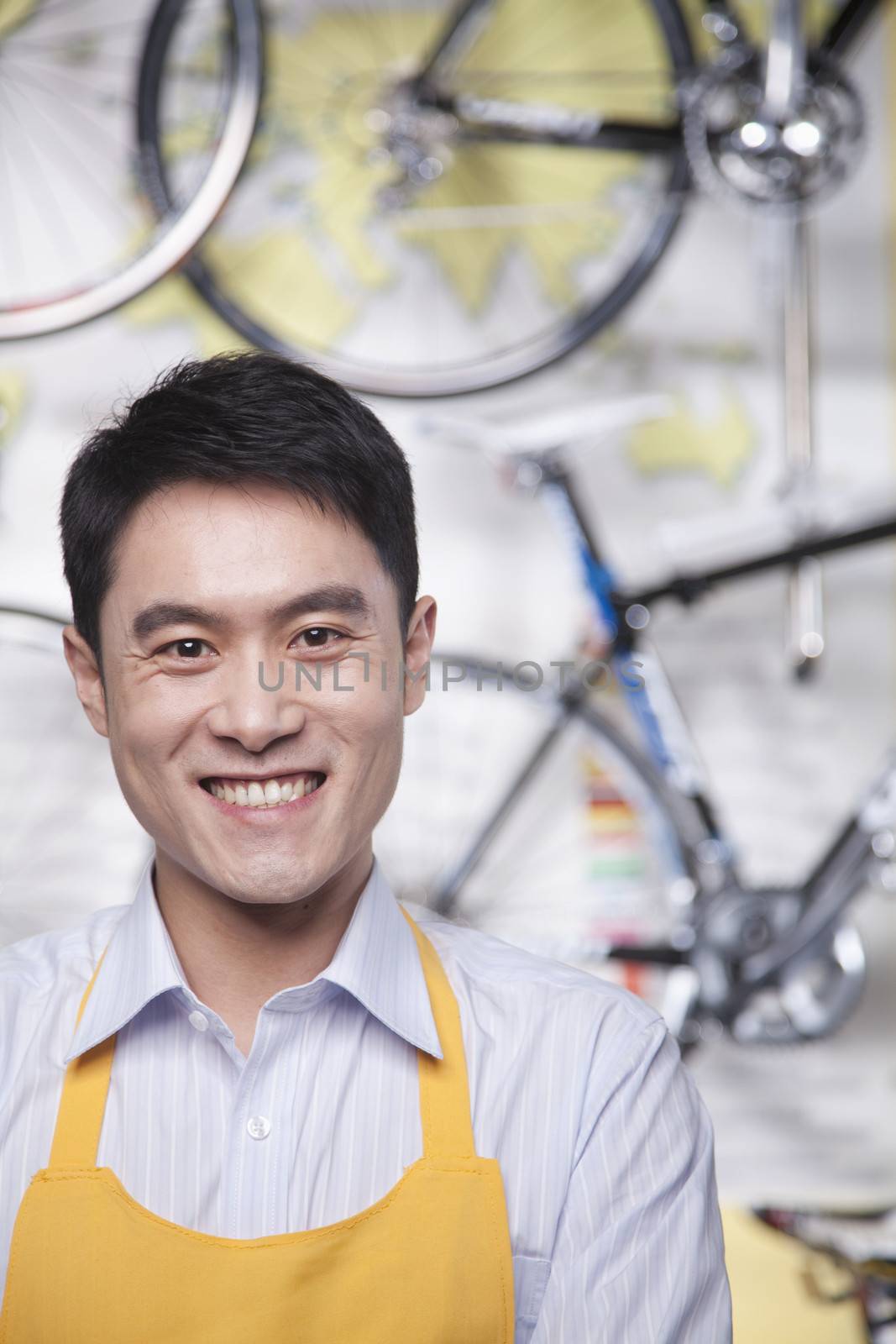 Portrait of young male mechanic in bicycle store, Beijing by XiXinXing