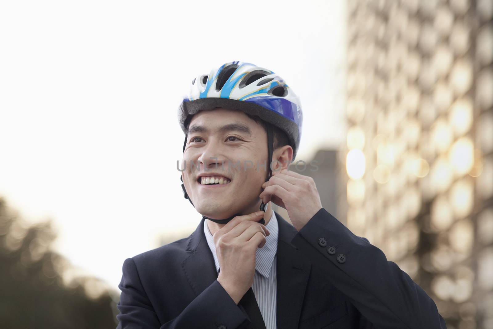 Businessman putting on cycling helmet