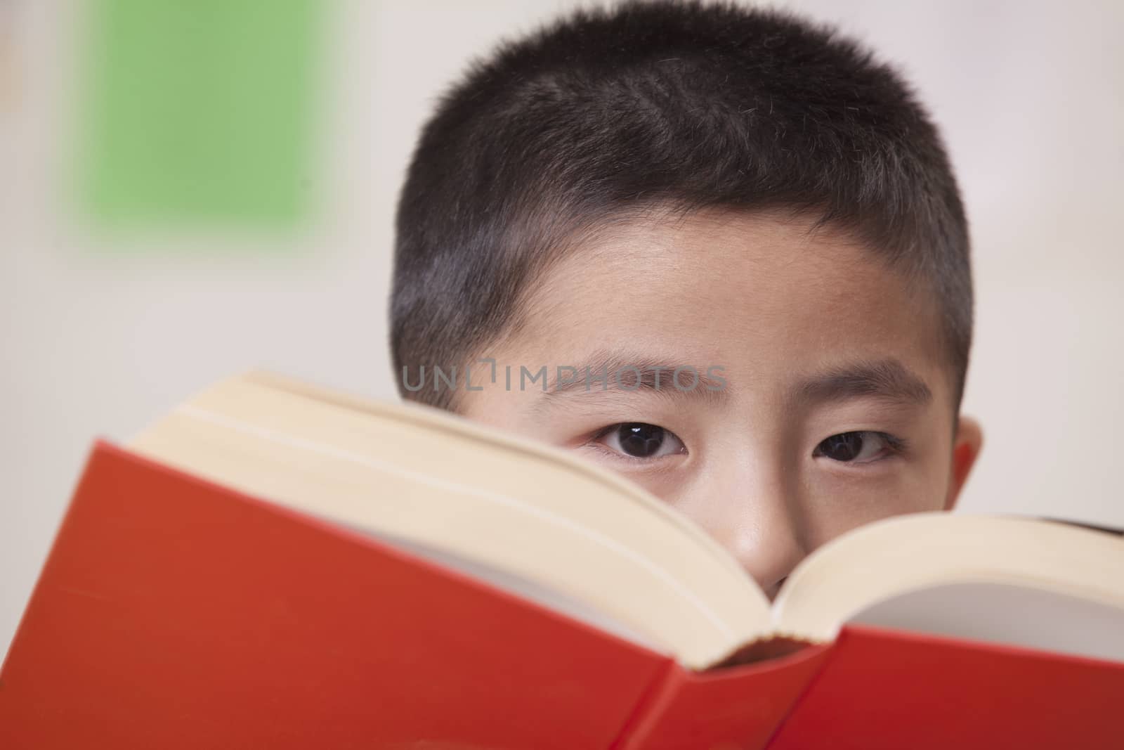 Boy Looking Over Book He's Reading