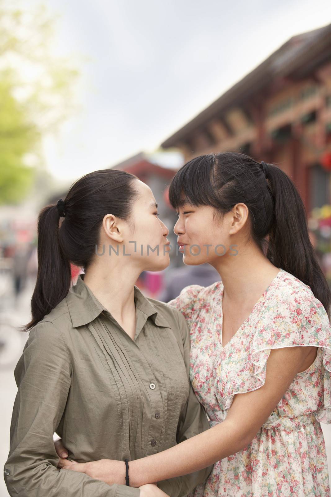 Two young women embracing by XiXinXing