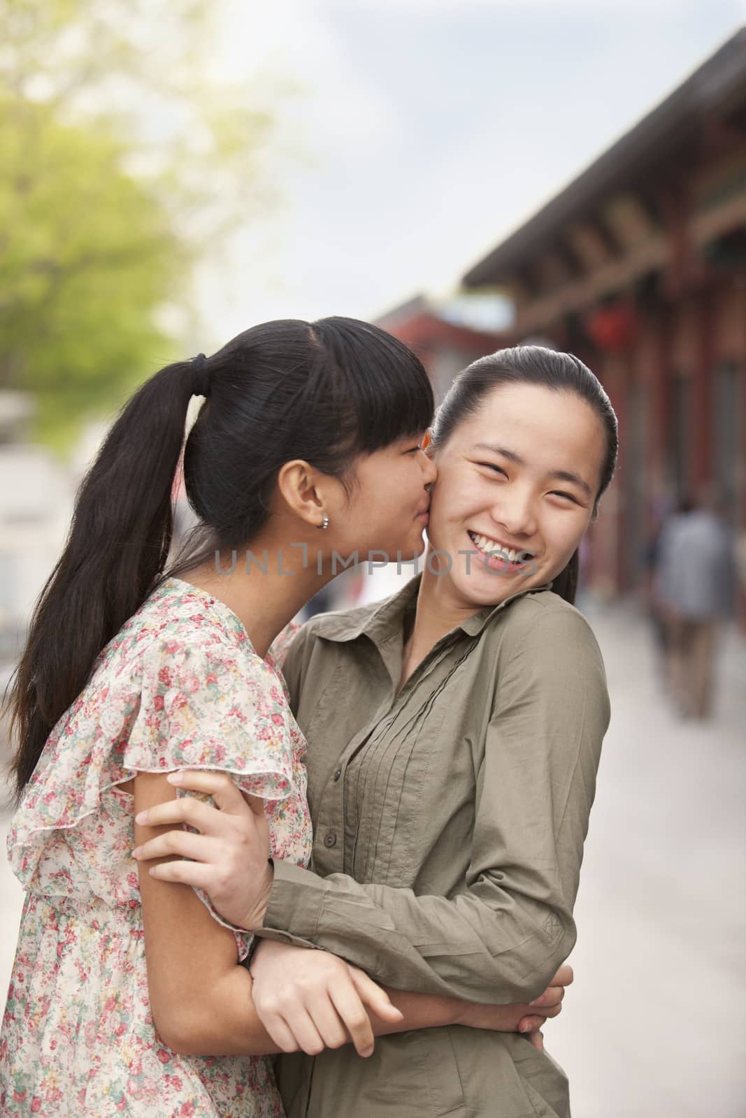Two young women embracing by XiXinXing