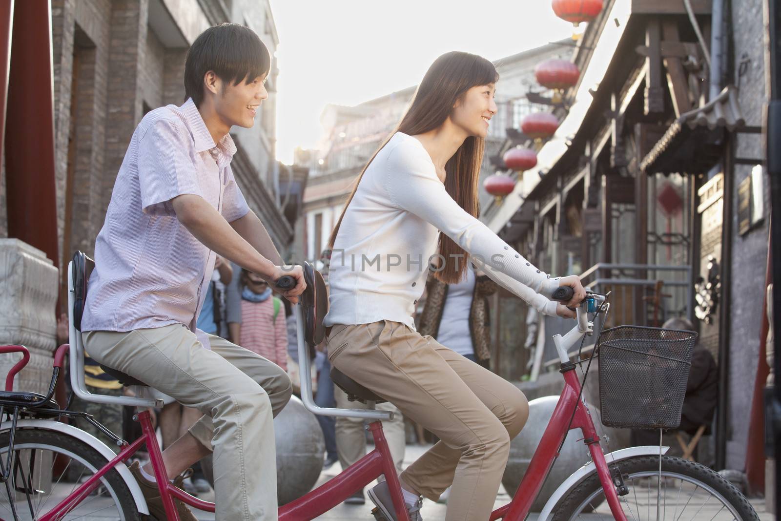 Side View of Young Heterosexual Couple on a Tandem Bicycle in Beijing 