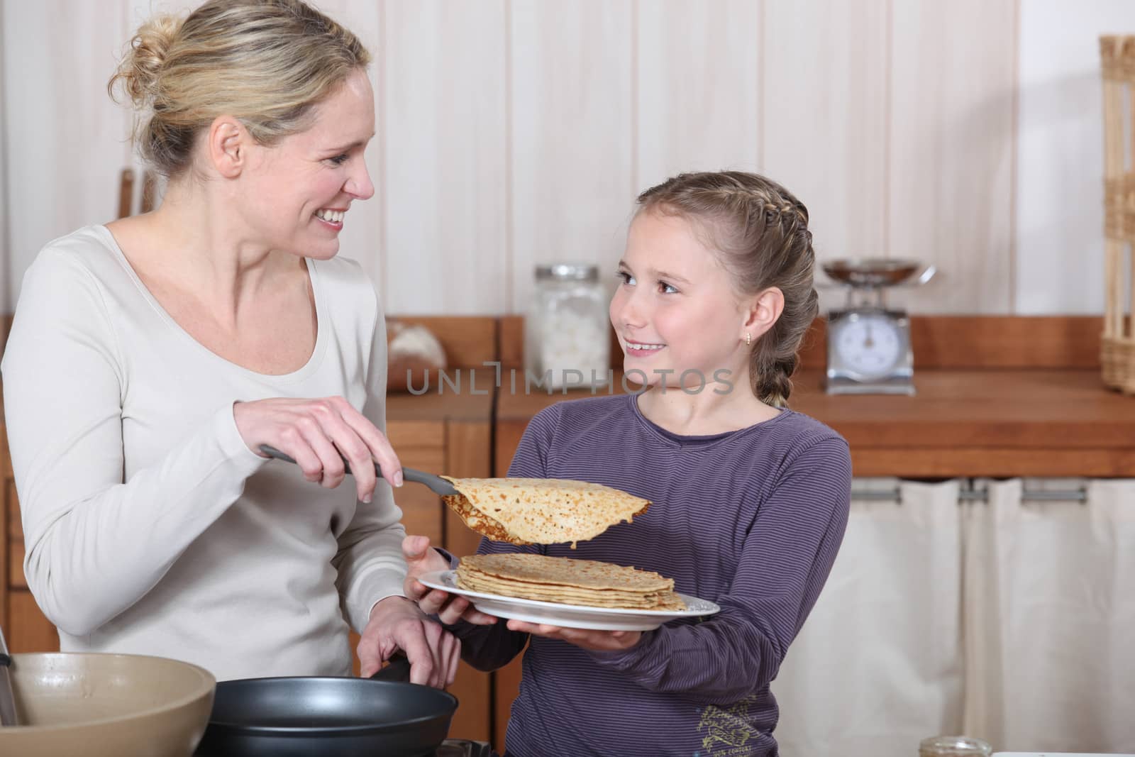 Little girl and mother about to eat pancakes for breakfast
