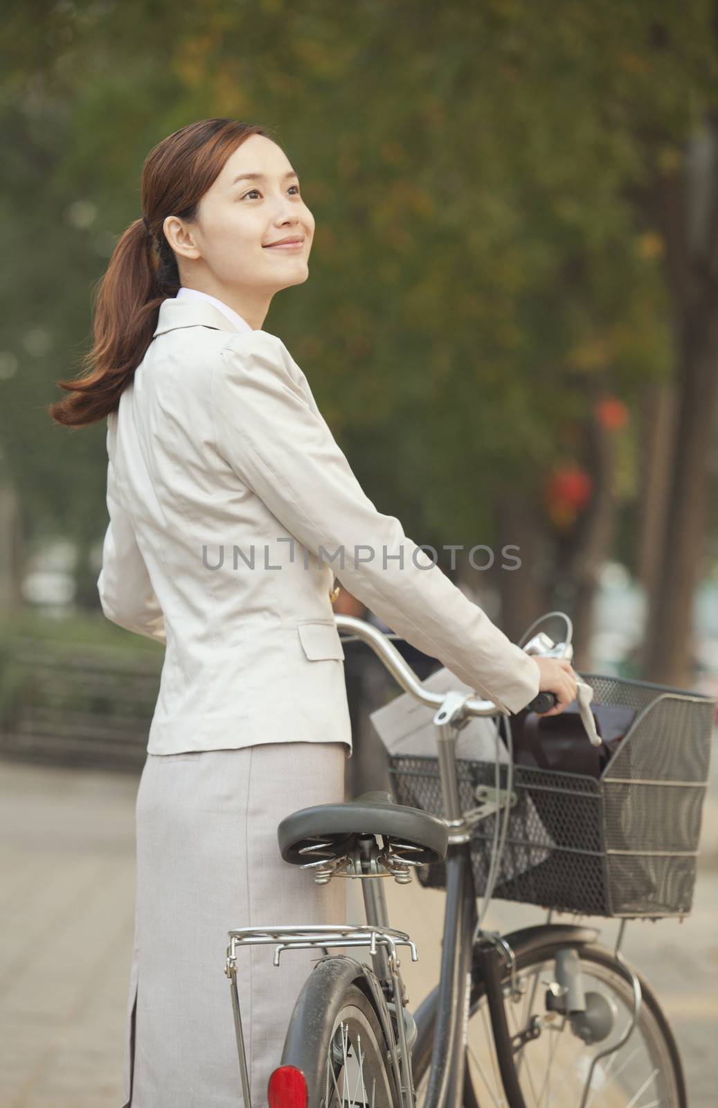 Young Business Woman standing with a Bicycle, Beijing, China