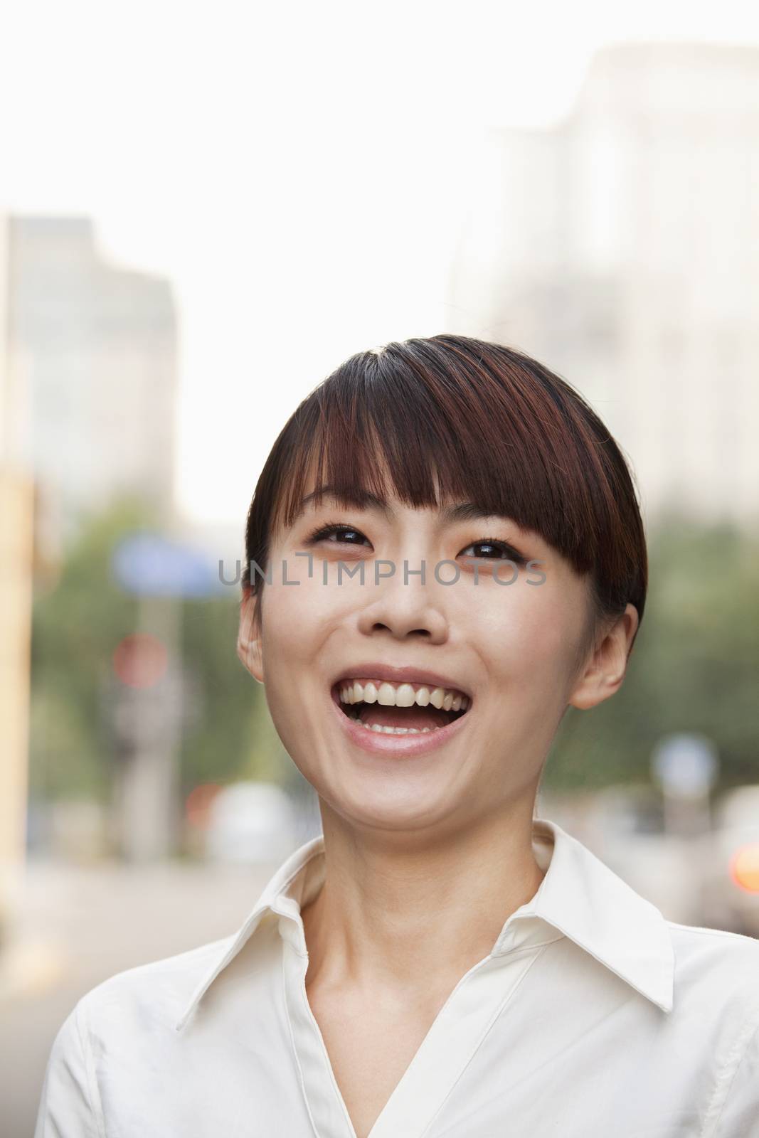 Portrait of young businesswoman laughing outside in Beijing 